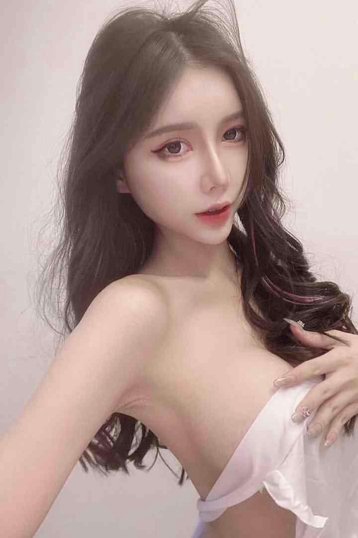 Beautiful Asian woman with long dark hair, wearing a white cloth, posing sensually.