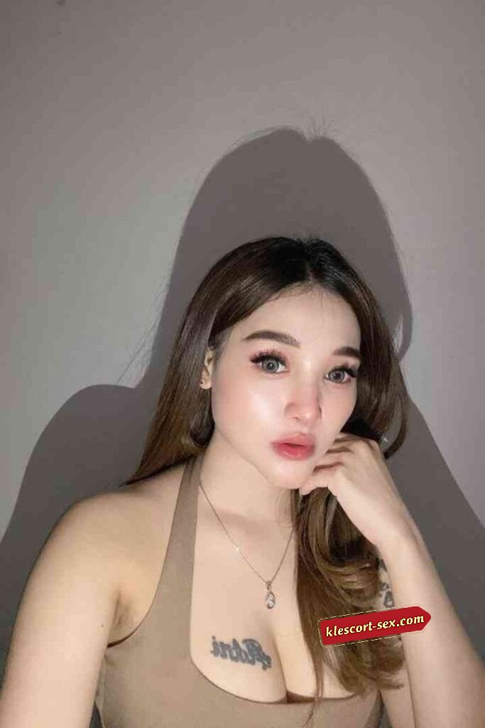 Attractive woman with brown hair posing with hand on chin.