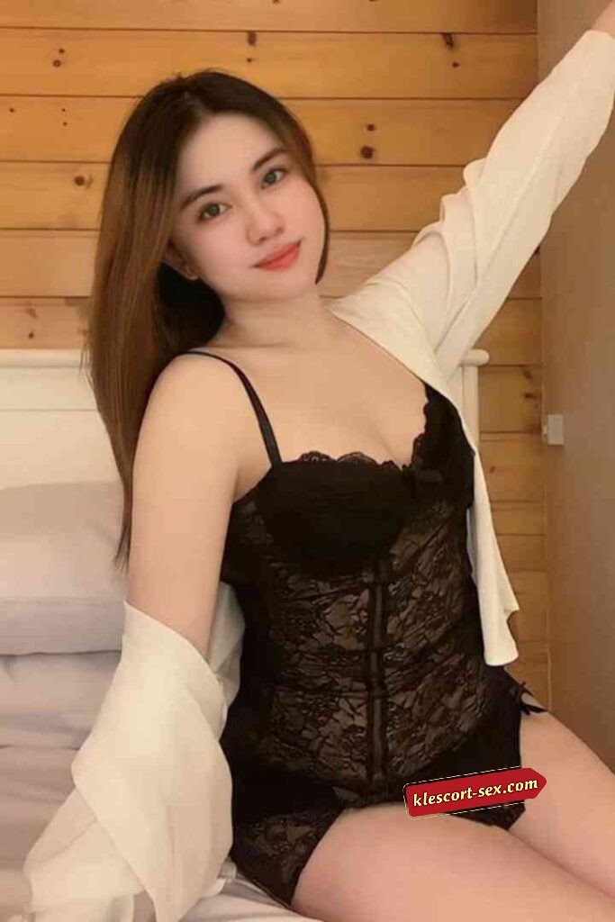 Woman in black lace lingerie and white shirt posing on bed. Beauty, fashion, and elegance.