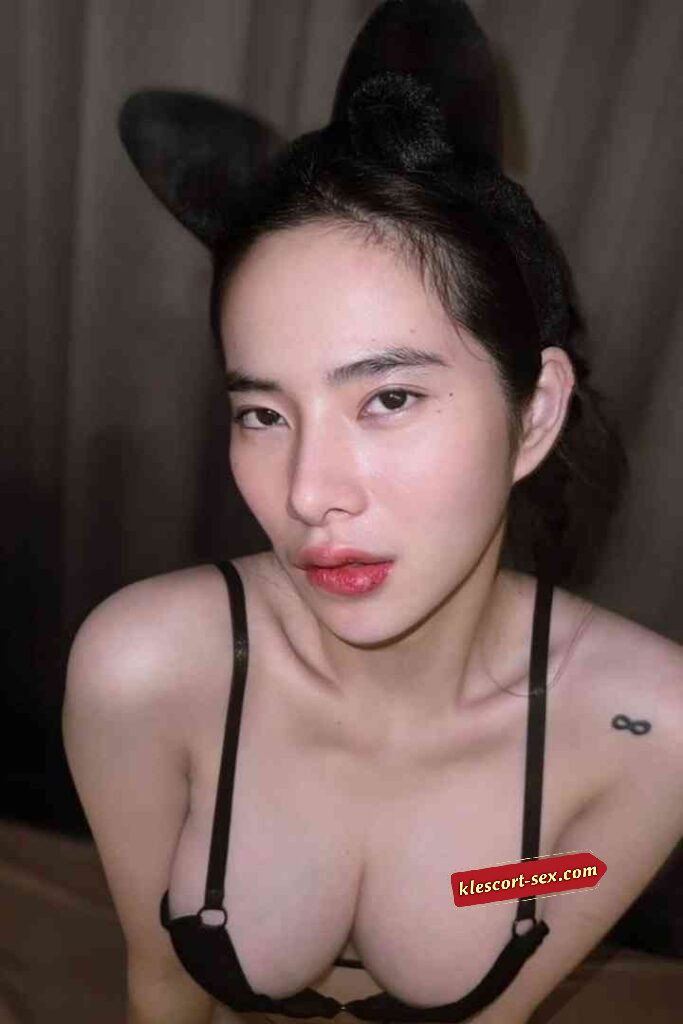 Woman with bunny ears and black lingerie top, infinity tattoo.