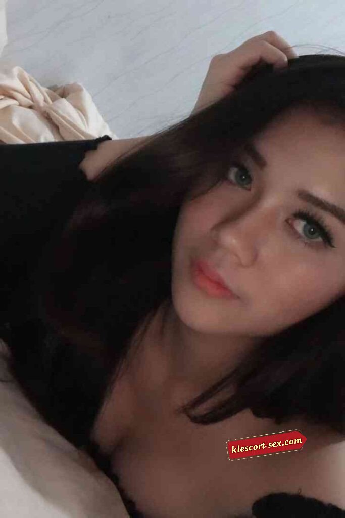 Portrait of a woman with dark hair and light eyes lying down.