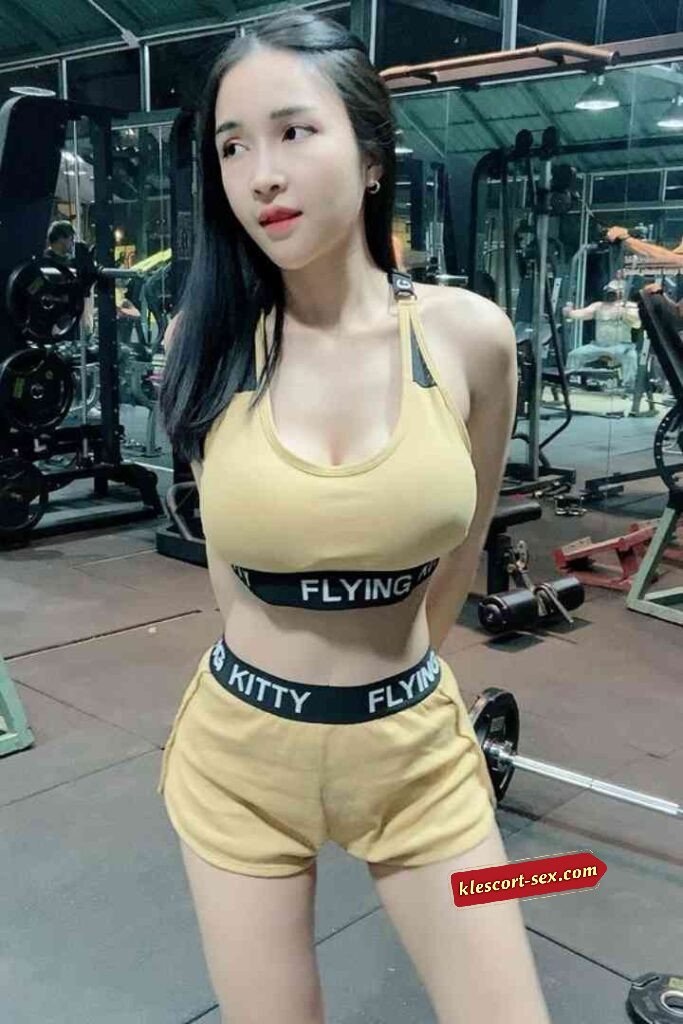 Woman in gym attire, Flying Kitty brand. Fitness workout.