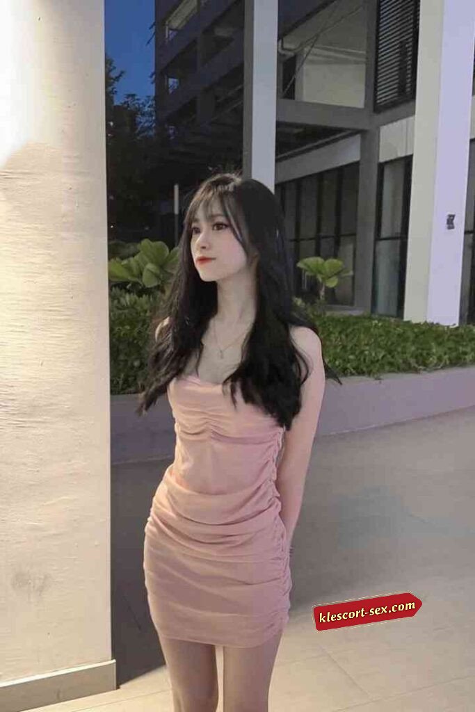 Young woman in pink dress outdoors at night.