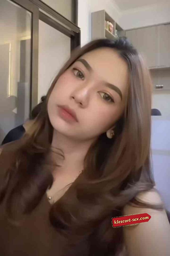 Portrait of a beautiful young woman with brown hair and soft makeup.