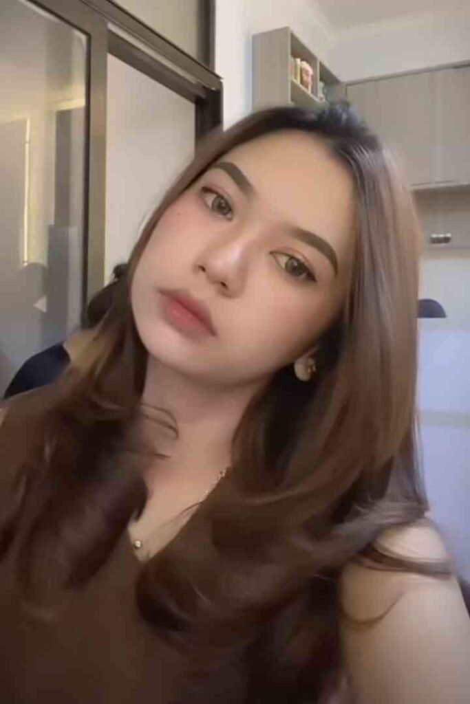 Portrait of a young woman with brown hair and light makeup.