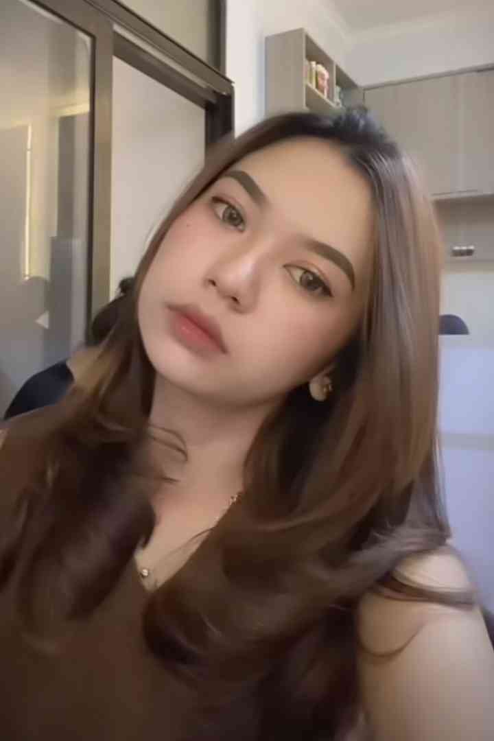 Portrait of a young woman with brown hair and light makeup.