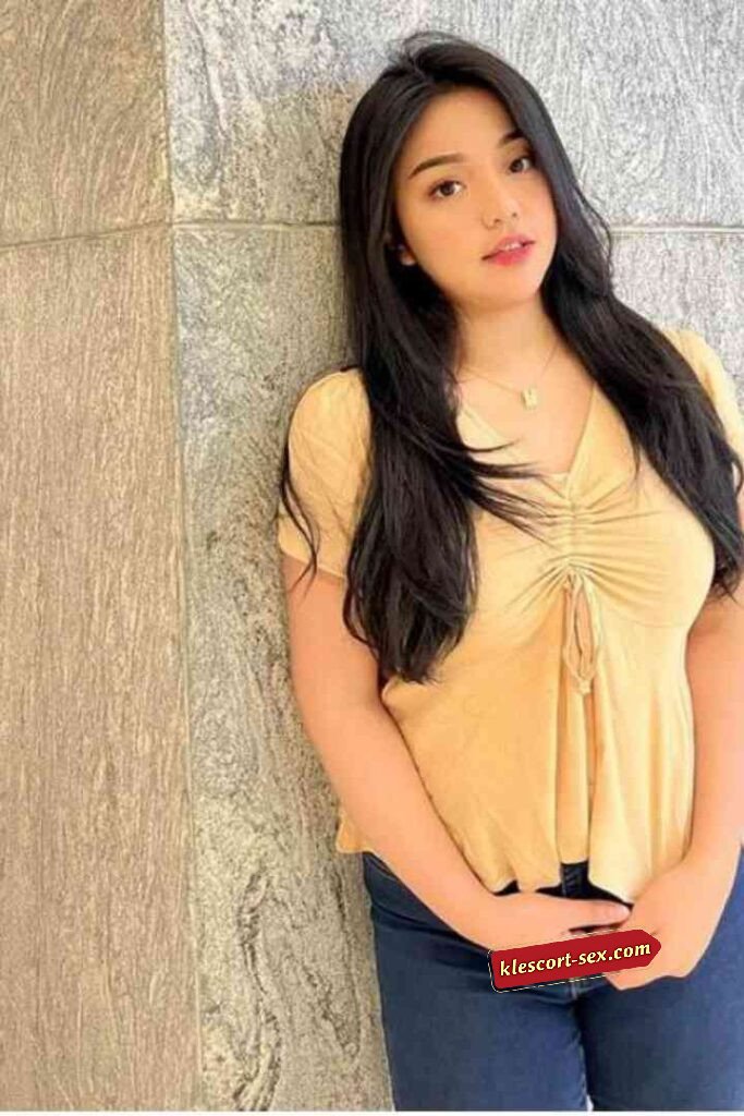 Portrait of a young woman with long dark hair in a yellow top.