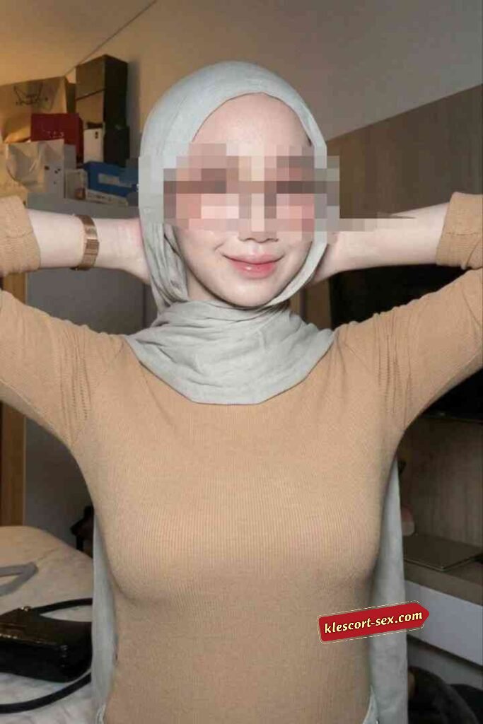 KL Escort Girl Woman in hijab and tan top smiling with hands behind head Sex Service Malaysia