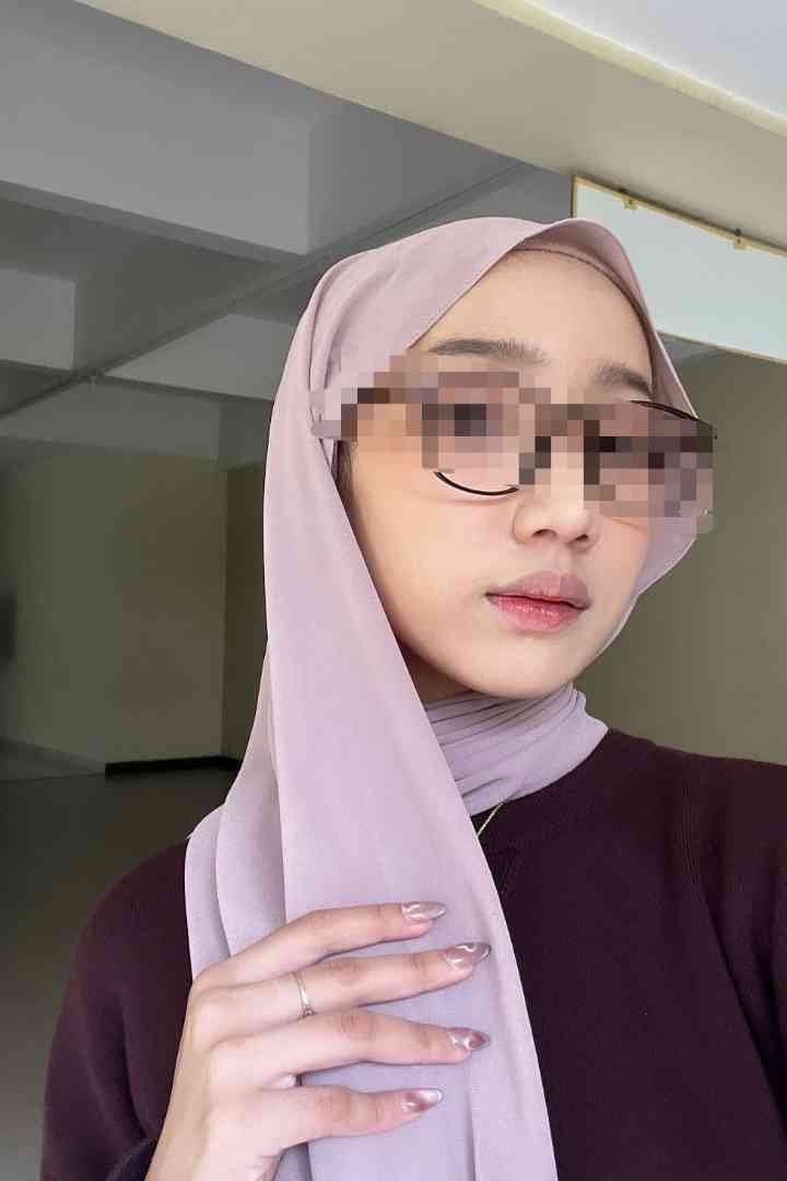 KL Escort Girl Woman wearing a pink hijab and glasses, with stylish nails Sex Service Malaysia
